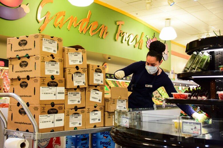 A commissary employee stocks produce