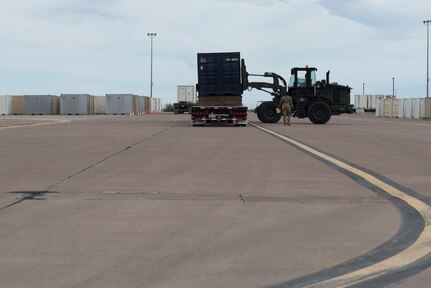 Airmen from the 635th Materiel Maintenance Group -- the Air Force’s only Basic Expeditionary Airfield Resources unit – load flatbed trucks with construction and maintenance equipment and cargo, April 9, 2020, on the BEAR Base ramp on Holloman Air Force Base. This equipment is being loaded and shipped to Joint Base San Antonio-Lackland, Texas within 48 hours of notification to support their contingency billeting capability during the COVID-19 crisis. This vital equipment will help ensure that the Air Force’s basic training pipeline will endure throughout the COVID-19 response. (U.S. Air Force photo by Tech. Sgt. Matthew Rosine)