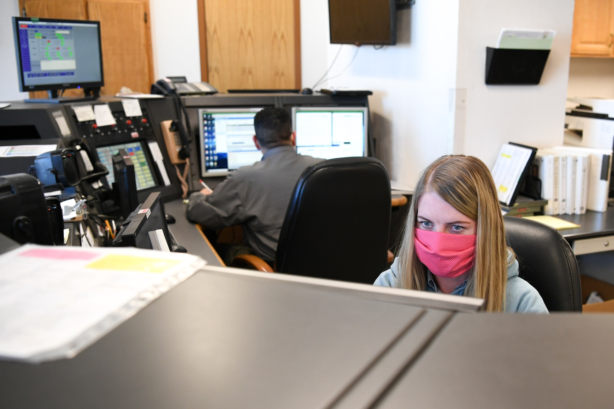 Workers looking at computers in the airfield management office.