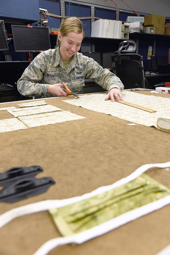 Airman First Class Sarah Talley, with the 552nd Air Control Network Squadron, cuts fabric which will be made into face masks to be donated to local hospice and medical facilities around the Tinker community. Fabric and materials were donated by a local store, Sew and Sews, for this project. Over 100 fabric masks have already been made and are ready to donate. (U.S. Air Force photo/Kelly White)