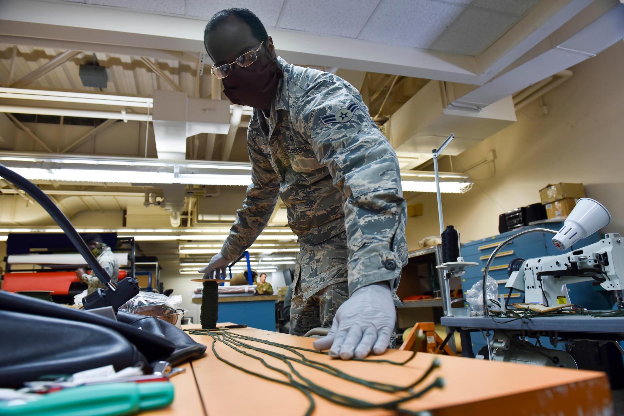 U.S. Air Force Airman 1st Class Ryan Richardson, 92nd Operation Support Squadron Aircrew Flight Equipment apprentice, measures paracord at Fairchild Air Force Base, Washington, April 10, 2020.  The paracord was cut and sewn into protective facemasks for Airmen to wear at Fairchild, during the COVID-19 pandemic. Force Health Protection remains one of Fairchild’s top priorities; with support of AFE and its Airmen, Fairchild is able to take proactive steps toward preventing the potential spread of respiratory illnesses, like the flu or COVID-19, amongst its Airmen, families and community. (U.S. Air Force photo by Senior Airman Lawrence Sena)