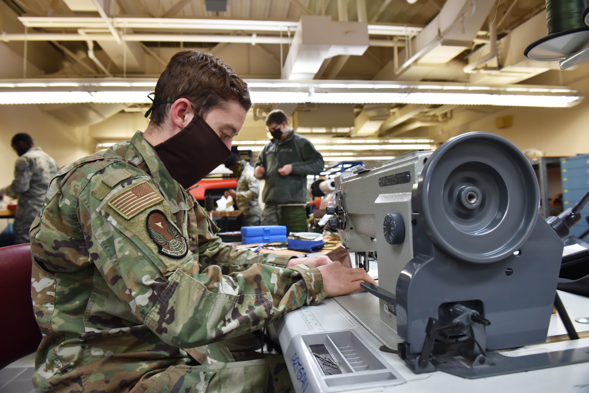 U.S. Air Force Staff Sgt. Cameron Harris, 92nd Operation Support Squadron Aircrew Flight Equipment craftsman, uses a sewing machine to create protective facemasks for Airmen to wear at Fairchild Air Force Base, Washington, April 10, 2020. AFE Airmen’s normal duties include managing the inspection, maintenance and adjustments of every piece of safety and flight equipment for all airframes with a “zero mistake” standard, in order to prevent equipment failures and accidents from happening. (U.S. Air Force photo by Senior Airman Lawrence Sena)