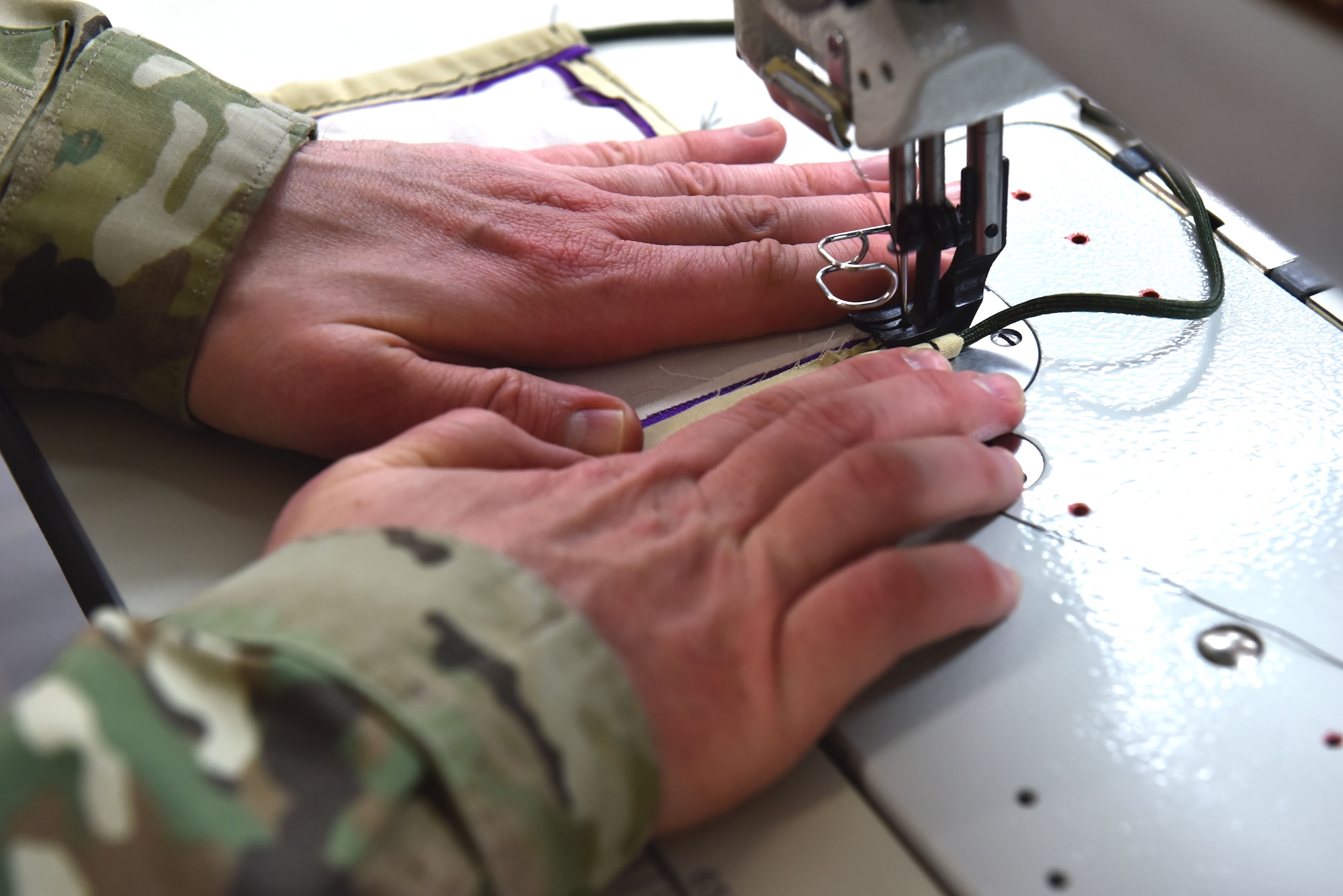 U.S. Air Force Master Sgt. Shawn Freed, 92nd Operation Support Squadron Aircrew Flight Equipment superintendent, uses a sewing machine to create protective facemasks for Airmen to wear at Fairchild Air Force Base, Washington, April 10, 2020. AFE was able to produce 250 masks within the first two days of receiving the task, and have produced over 650 more for Airmen on the installation to wear. (U.S. Air Force photo by Senior Airman Lawrence Sena)