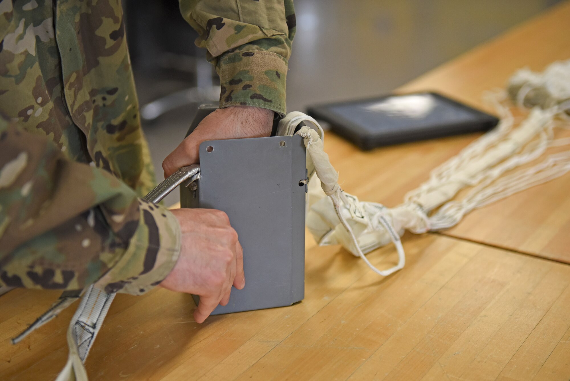 A U.S. Air Force Airman assigned to the 8th Operations Support Squadron aircrew flight equipment section, repacks a drogue parachute at Kunsan Air Base, Republic of Korea, April 13, 2020. From packing emergency items, like parachutes and survival kits, to maintaining regularly used items, like helmets and oxygen masks, attention to detail is of the utmost importance for AFE technicians. (U.S. Air Force photo by Staff Sgt. Mackenzie Mendez)