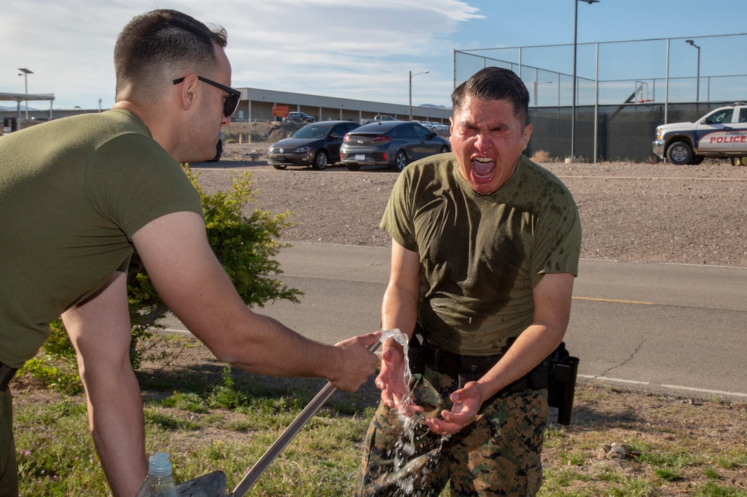 Lance Corporal Jeremy J. Tom, warehouse clerk, screams in pain as Lance Cpl. Noah M. Avila, data systems administrator, tries to help him by spraying him with cold water, after Tom was sprayed with OC spray as part of the Security Augmentation Force training held aboard Marine Corps Logistics Base Barstow, Calif., April 1.