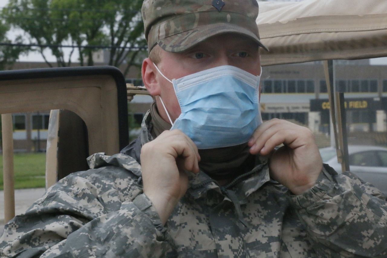 Head-and-shoulders shot of a soldier wearing a light-blue face mask.