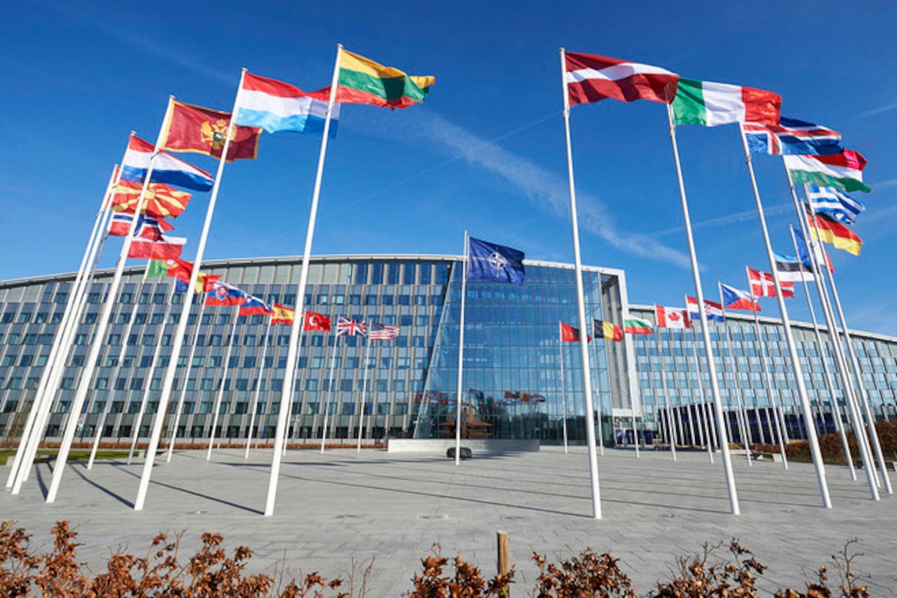 A building with a circle of flags in front of it.