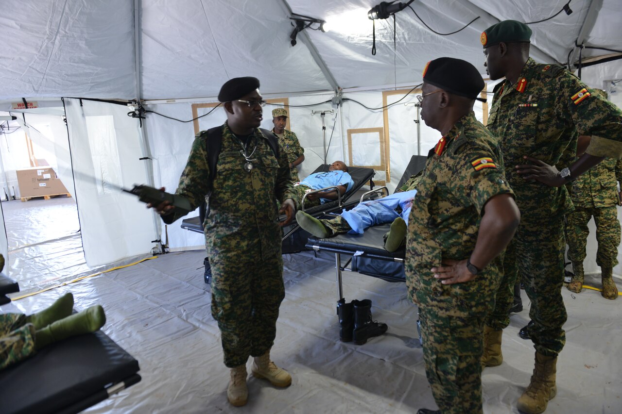 Ugandan officer briefs Ugandan soldiers on the layout of a mobile treatment facility.