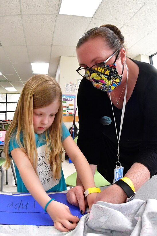 Bethany Powell, left, is helped by Sarah Wheelwright.