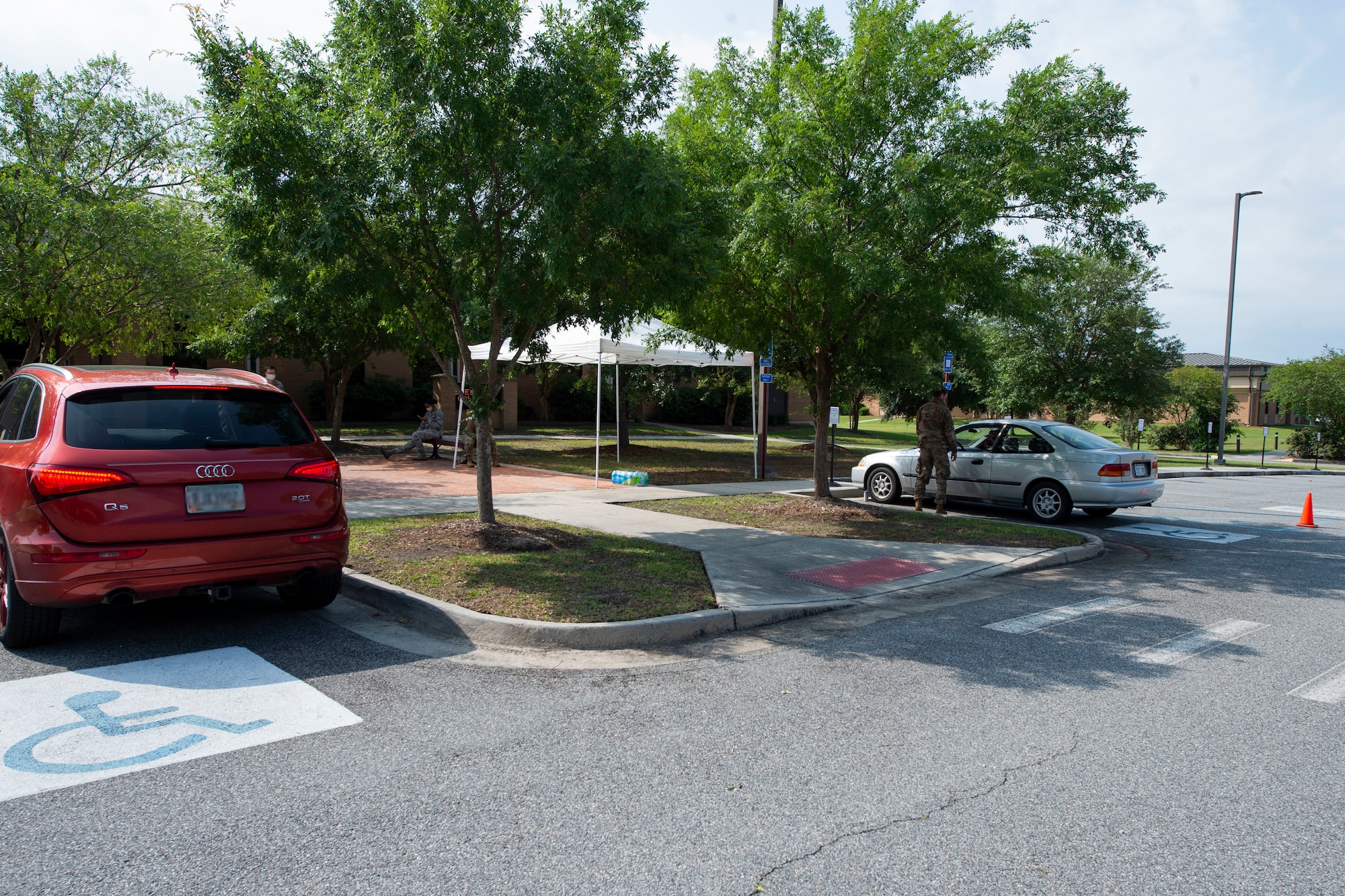 Photo of beneficiaries waiting in a parking lot.