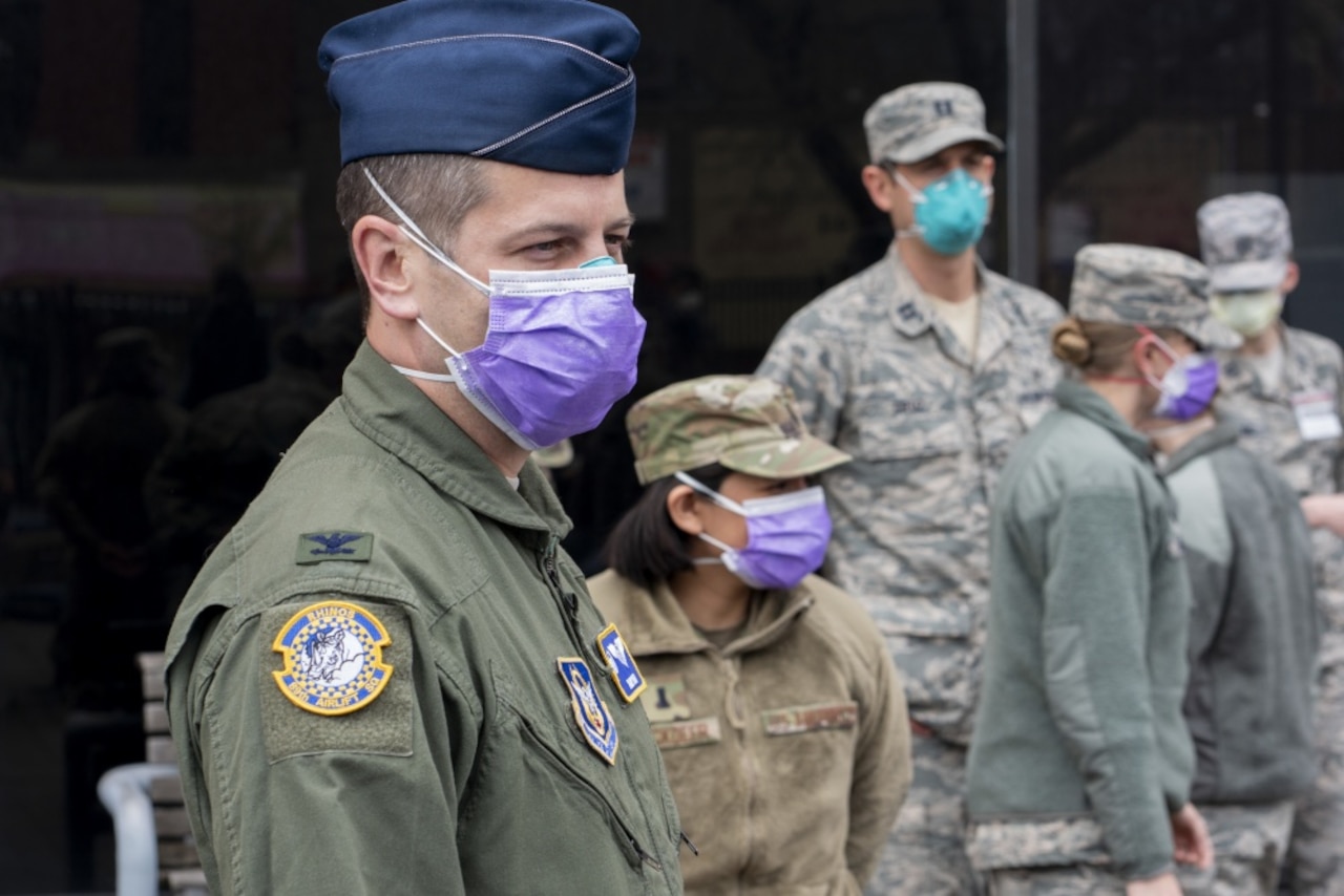 Service members wear face masks.