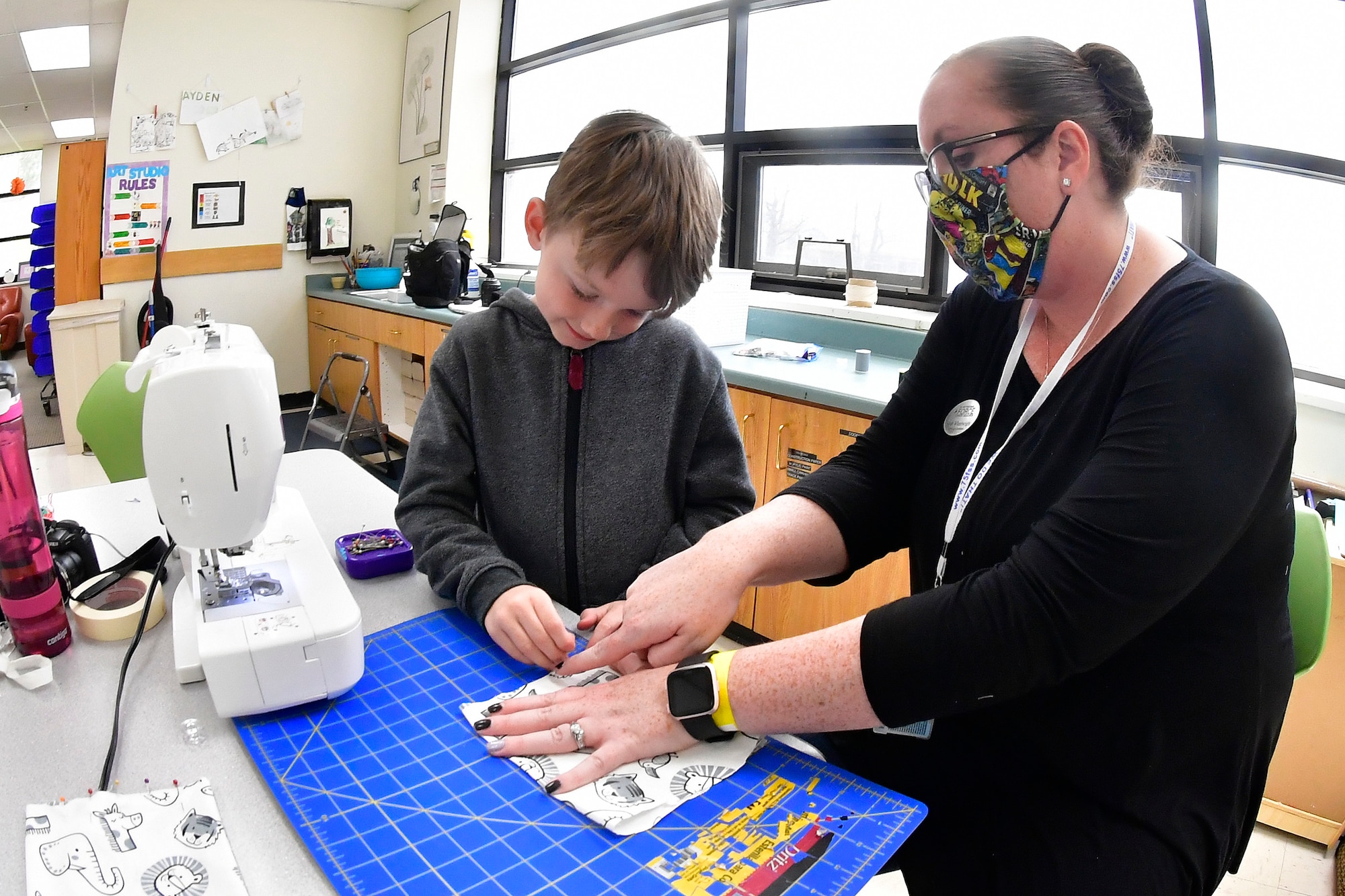 David Warren, left, pinning the mask material to a pattern is helped by Sarah Wheelwright.