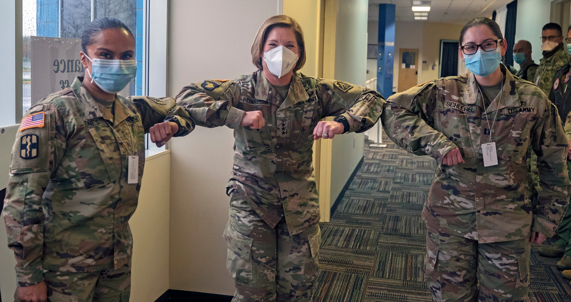 Lt. Gen. Laura Richardson, commanding general of U.S. Army North, bumps elbows with Maj. Shubhra Jones and Capt. Alyssa Schlegel, medical personnel working at the Edison Field Medical Site in Edison, New Jersey, during her visit April 13, 2020.