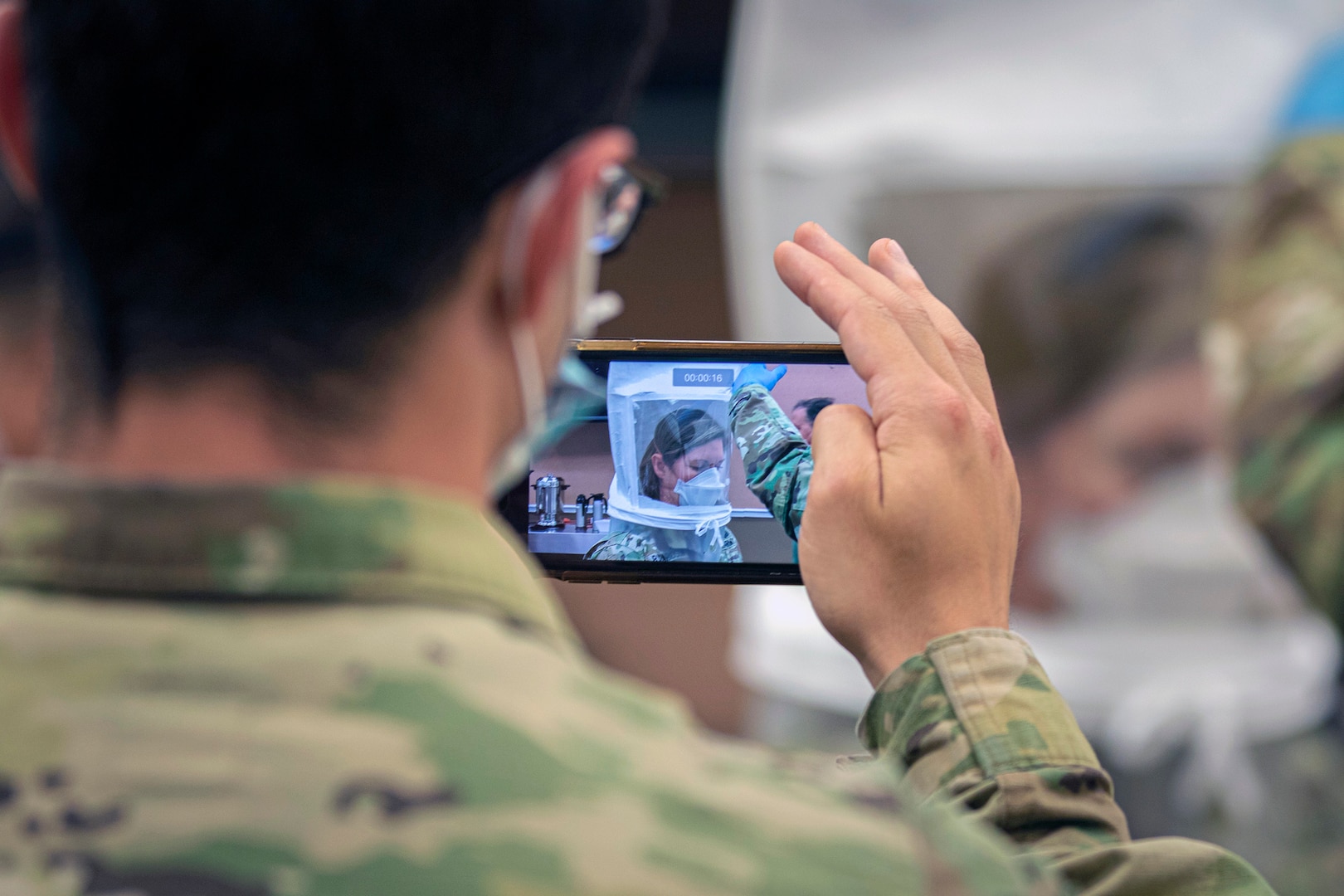 A Soldier records a video of Lt. Gen. Laura Richardson, commanding general of U.S. Army North, going through the safety precautions before entering the patient ward of the Edison Field Medical Site in Edison, New Jersey, April 13, 2020.