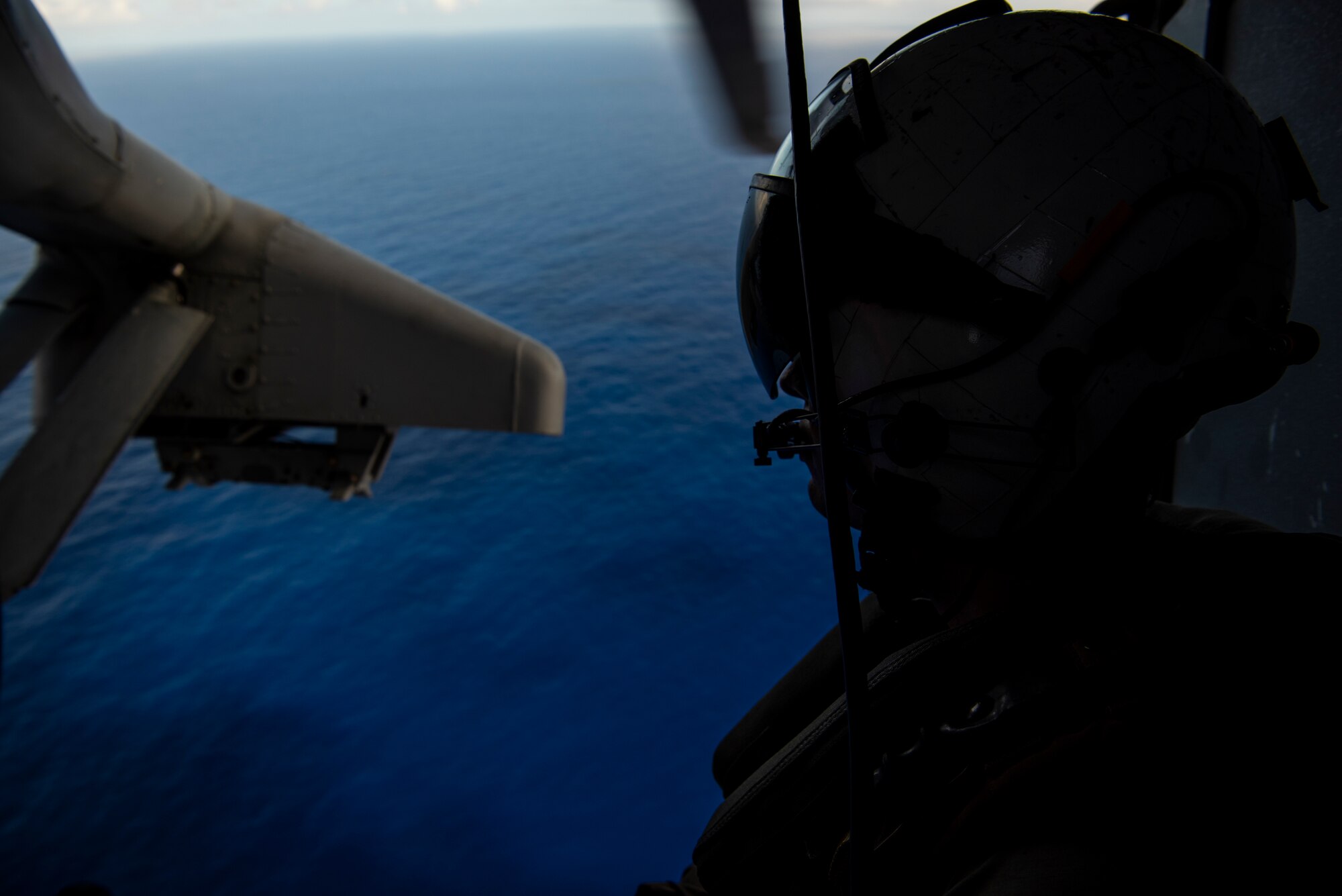 U.S. Navy Air Crewman 2nd Class Zach Morrissey (Helicopter) assigned to Helicopter Sea Combat Squadron 25, travels over Andersen Air Force Base, Guam, during an “Elephant Walk” in an MH-60S Knighthawk over the Pacific Ocean, April 13, 2020.