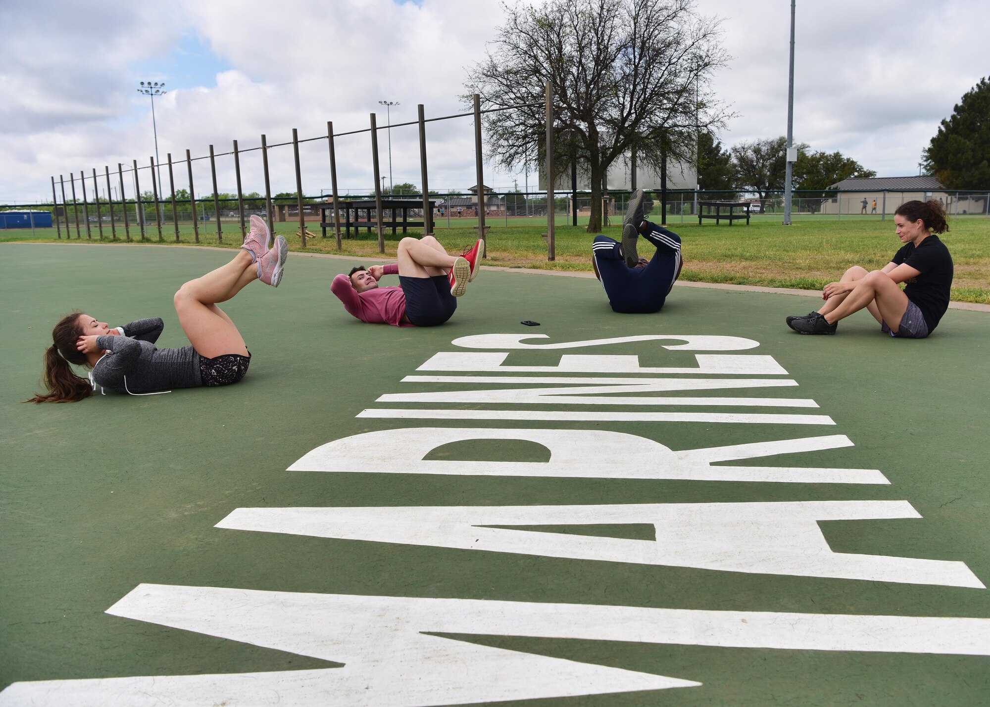 Members of ‘Dream Team’, one of the competition winners, compete in the sit-up portion of the ‘Break the Pandemic’ Morale event on Goodfellow Air Force Base, Texas, April 11, 2020. The 315th Training Squadron hosted the event to give members of Team Goodfellow a way to interact while observing social distancing regulations in response to the COVID-19 pandemic. (U.S. Air Force photo by Staff Sgt. Chad Warren)