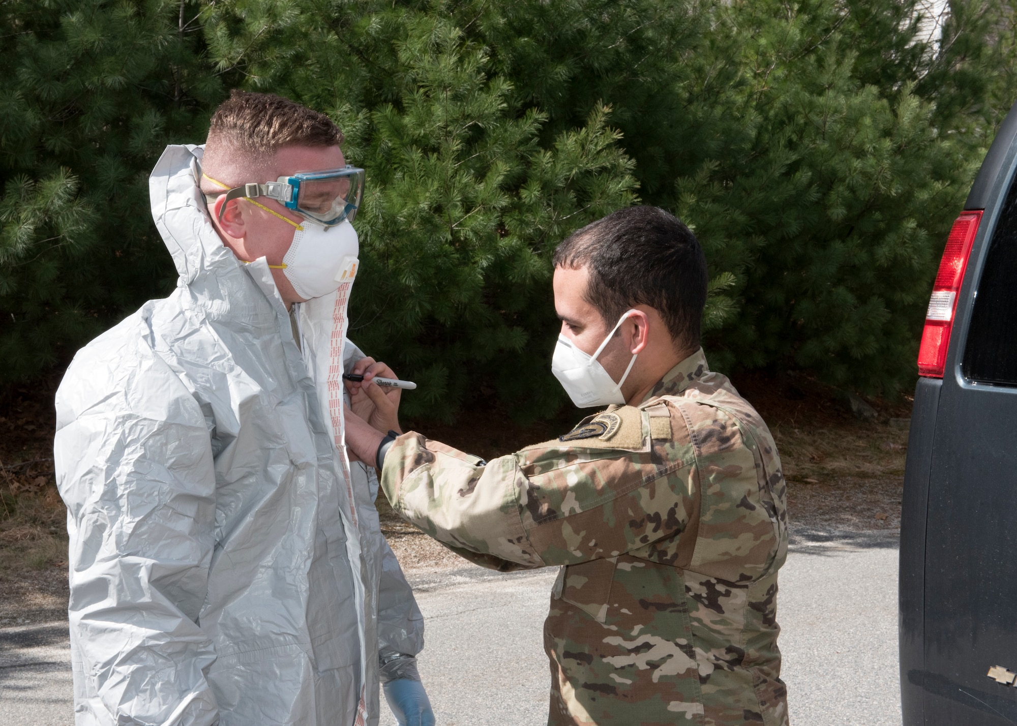 Soldiers and Airmen from the Massachusetts National Guard don proper personal protective equipment (PPE)