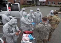 Soldiers and Airmen from the Massachusetts National Guard don proper personal protective equipment (PPE)