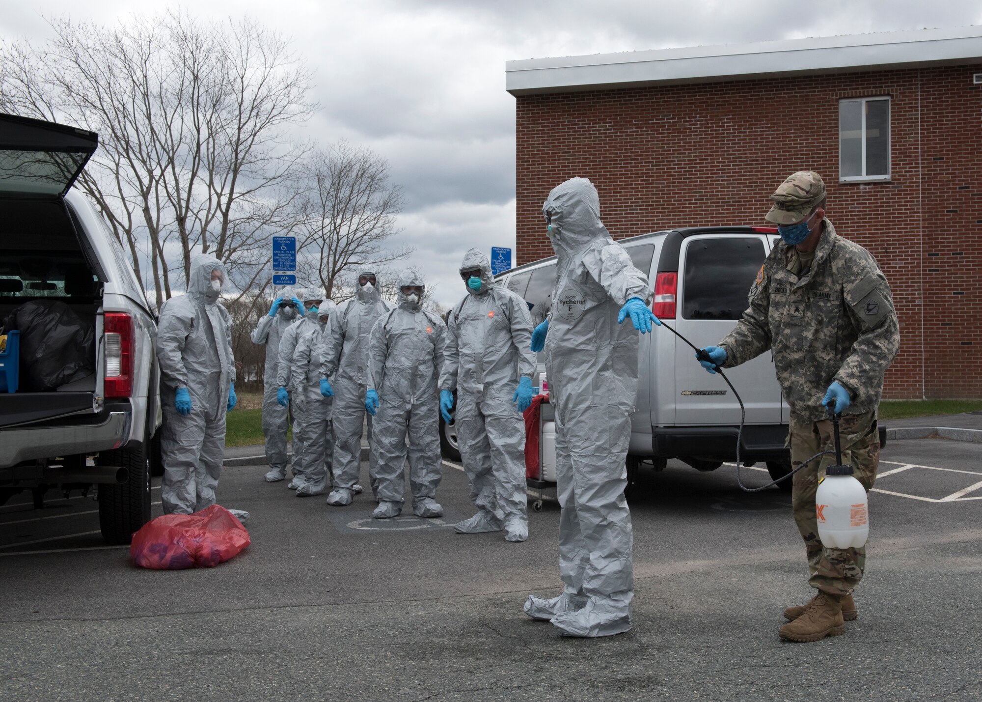 Soldiers and Airmen from the Massachusetts National Guard go through a detailed decontamination process and remove their personal protective equipment (PPE)