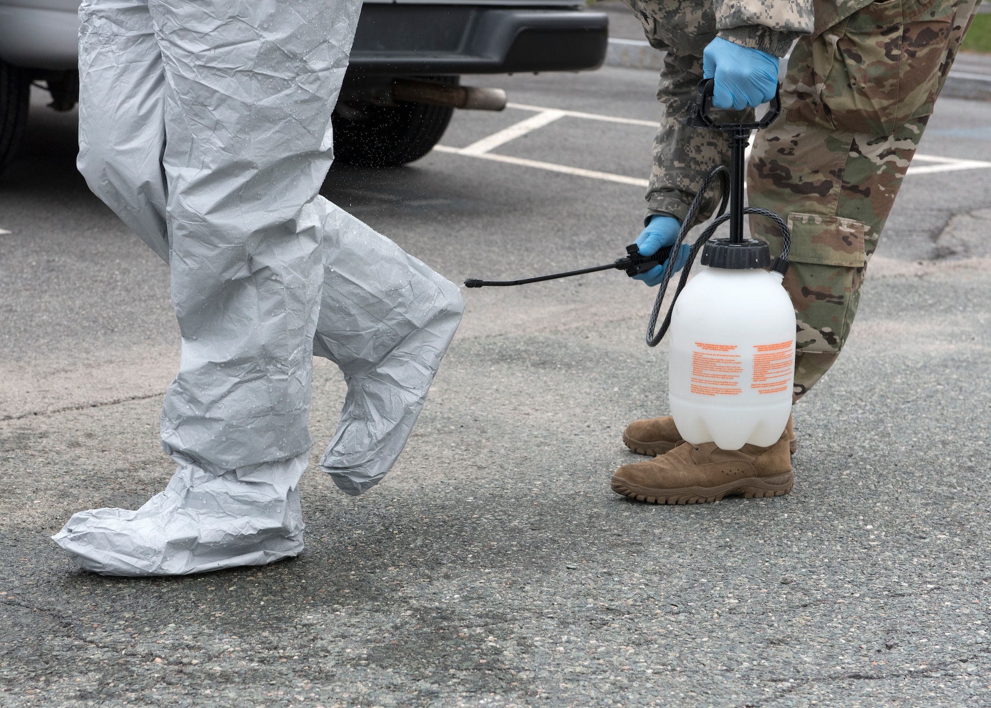 Soldiers and Airmen from the Massachusetts National Guard go through a detailed decontamination process and remove their personal protective equipment (PPE)