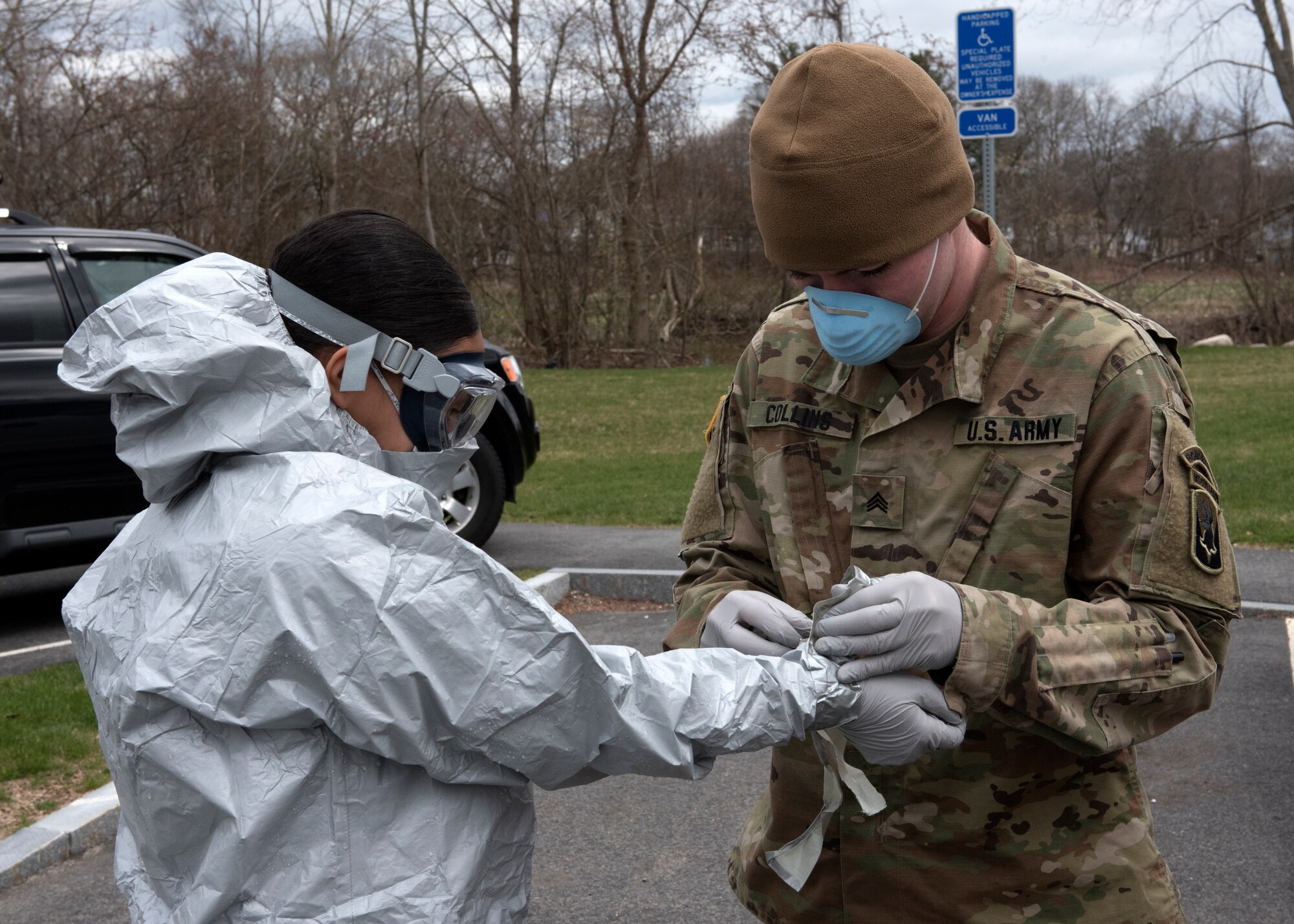 Soldiers and Airmen from the Massachusetts National Guard go through a detailed decontamination process and remove their personal protective equipment (PPE)
