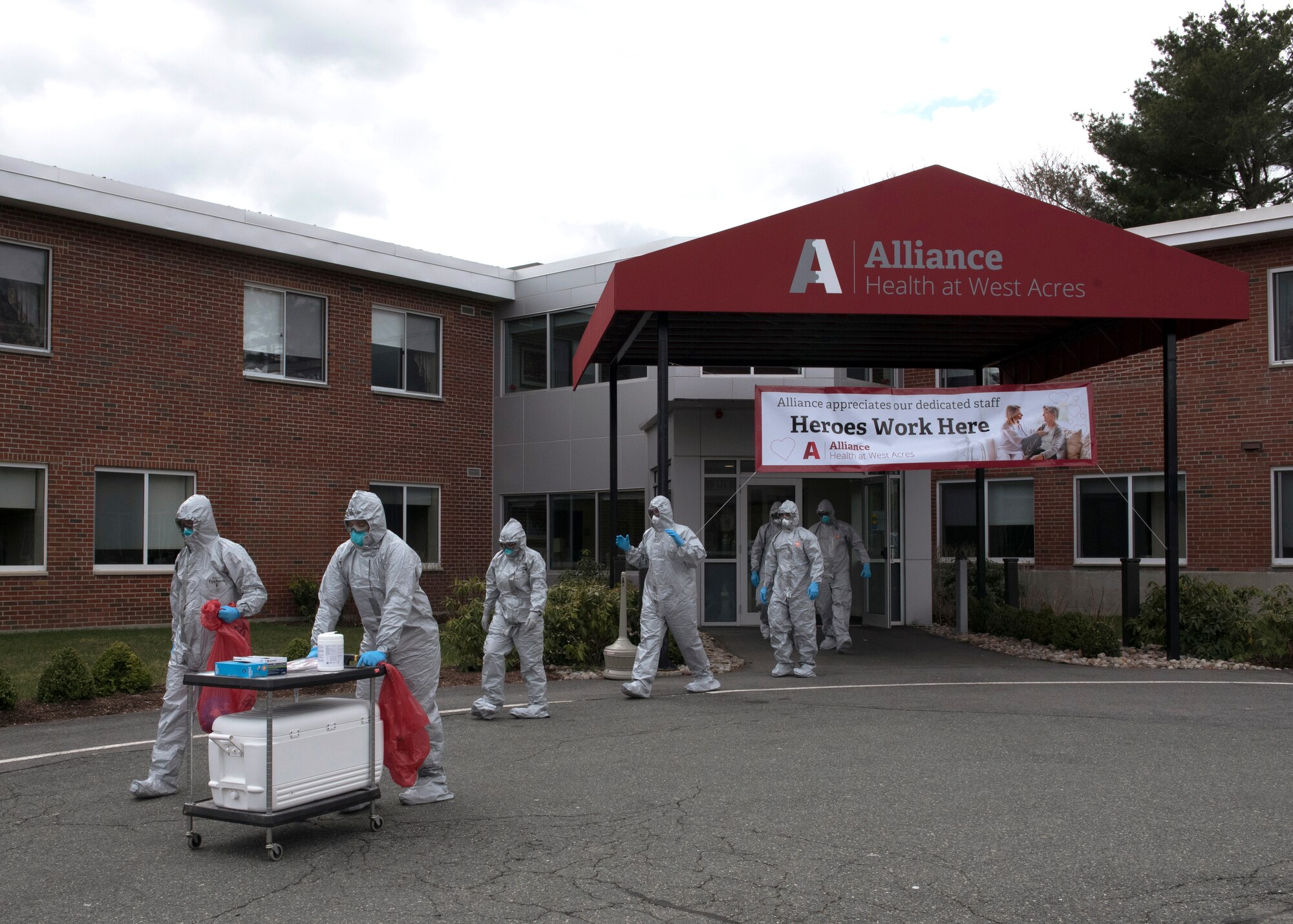 Soldiers and Airmen from the Massachusetts National Guard don proper personal protective equipment (PPE)