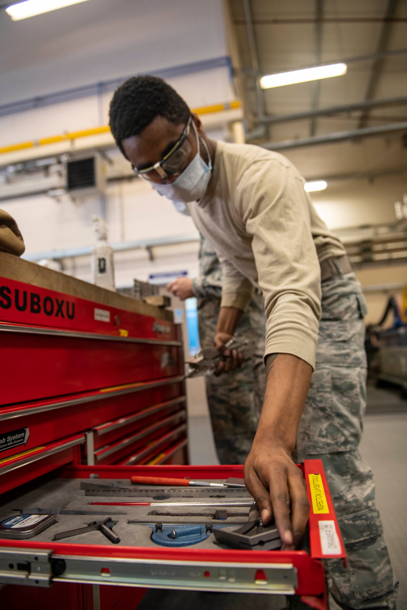 Airman 1st Class Jevaughn Harvey, 100th Maintenance Squadron aircraft structural maintenance apprentice, puts tools away after doing a training project at RAF Mildenhall, England, April 8, 2020. Airmen at the 100th MXS aircraft structural maintenance shop stay ready for the mission by conducting training projects such as taking out stuck screws from metal sheets. (U.S. Air Force Staff Sgt. Luke Milano)