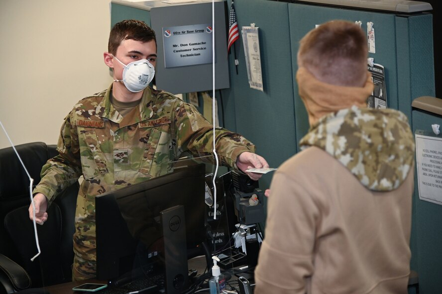 Senior Airman Dominik Daigneault, Force Support Squadron force management journeyman, hands a newly issued Common Access Card to Lance Cpl. Alex Merloni of the 1st Battalion, 25th Marines, Fort Devens, Mass., at the Military Personnel Flight office on Hanscom Air Force Base, Mass., April 13.