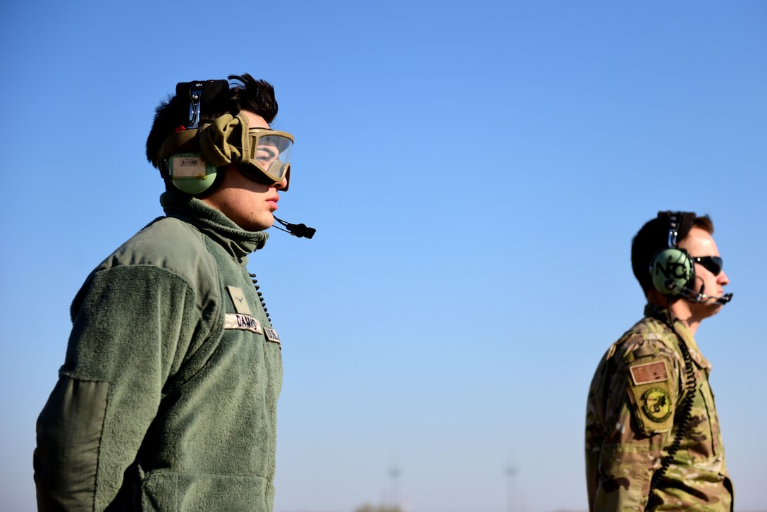 U.S. Air Force Airman Caesar Damas, left, and Senior Airman Joshua Lack, 31st Aircraft Maintenance Squadron, 56th Helicopter Maintenance Unit crew chiefs, watch as an HH-60G Pave Hawk prepares for takeoff at Aviano Air Base, Italy, April 2, 2020. Crew chiefs, or tactical aircraft maintainers, are in charge of inspecting, troubleshooting, and maintaining aircraft structures, hydraulics, and other related systems, components, and equipment. (U.S. Air Force photo by Staff Sgt. Kelsey Tucker)