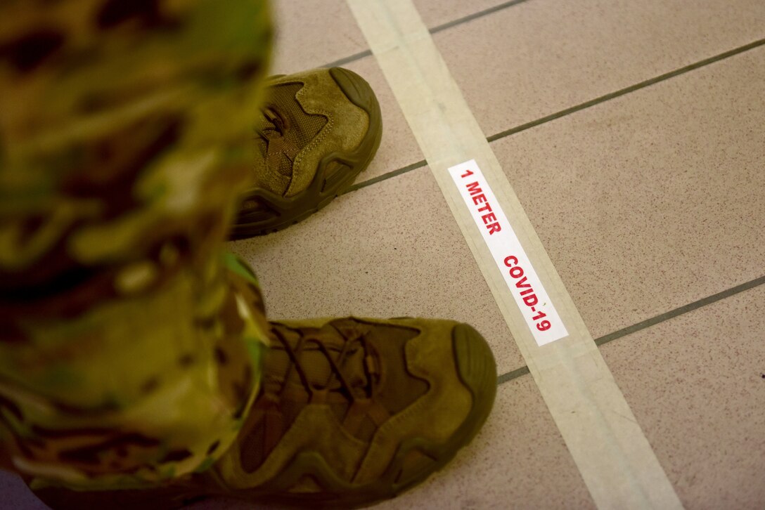 U.S. Air Force Maj. Allan Sain, 56th Rescue Squadron (RQS) HH-60G Pave Hawk pilot, stands behind a marked 1-meter line at Aviano Air Base, Italy, April 2, 2020. Airmen of the 56th RQS implemented several measures in response to the COVID-19 crisis, including physical distancing and the separation of the squadron into several teams. (U.S. Air Force photo by Staff Sgt. Kelsey Tucker)