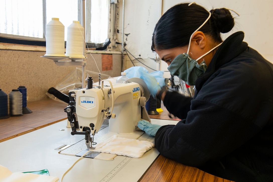 A sailor looks at a sewing machine on a table.