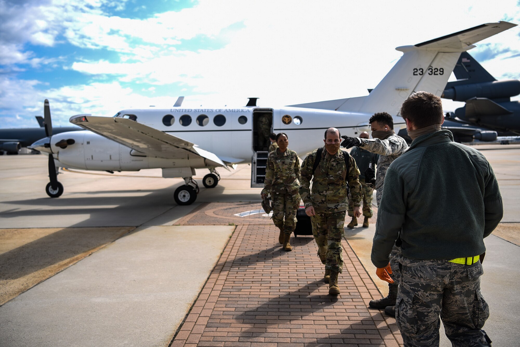 Photo of Airmen directing soldiers where to go on the flightline.