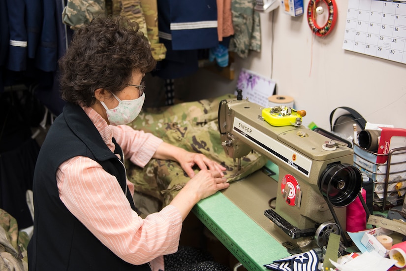 Kum Sun Yun, the manager of Stripes Alterations Shop, sews a uniform top at Joint Base Charleston, S.C., April 7, 2020. Employees at Stripes Alterations Shop are taking safety precautions such as wearing masks, cleaning work areas and washing their hands frequently. The hours of operation for alterations are from 9 a.m. to 5 p.m. Monday through Friday and 9 a.m. to 3 p.m. on Saturdays.