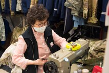 Kum Sun Yun, the manager of Stripes Alterations Shop, alters a uniform top at Joint Base Charleston, S.C., April 7, 2020. Employees at Stripes Alterations Shop are taking safety precautions such as wearing masks, cleaning work areas and washing their hands frequently. The hours of operation for alterations are from 9 a.m. to 5 p.m. Monday through Friday and 9 a.m. to 3 p.m. on Saturdays.