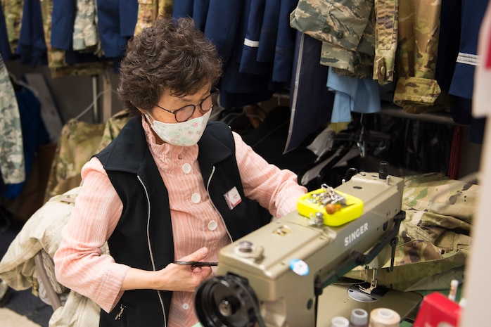 Kum Sun Yun, the manager of Stripes Alterations Shop, alters a uniform top at Joint Base Charleston, S.C., April 7, 2020. Employees at Stripes Alterations Shop are taking safety precautions such as wearing masks, cleaning work areas and washing their hands frequently. The hours of operation for alterations are from 9 a.m. to 5 p.m. Monday through Friday and 9 a.m. to 3 p.m. on Saturdays.
