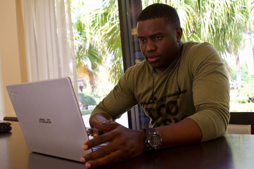 A man works on a laptop in his home.