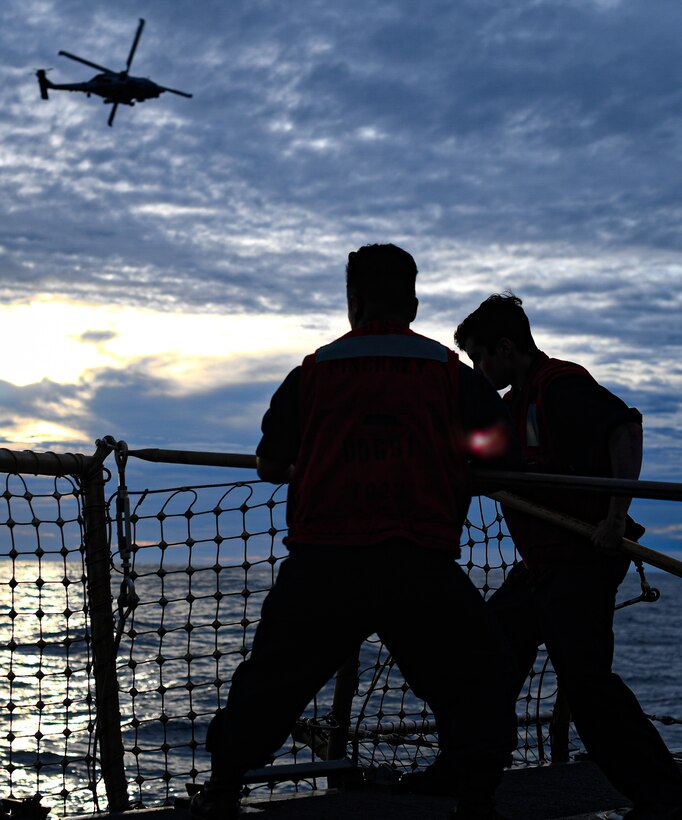 Sailors lower safety nets on the flight deck of USS Pinckney April 14, 2020.