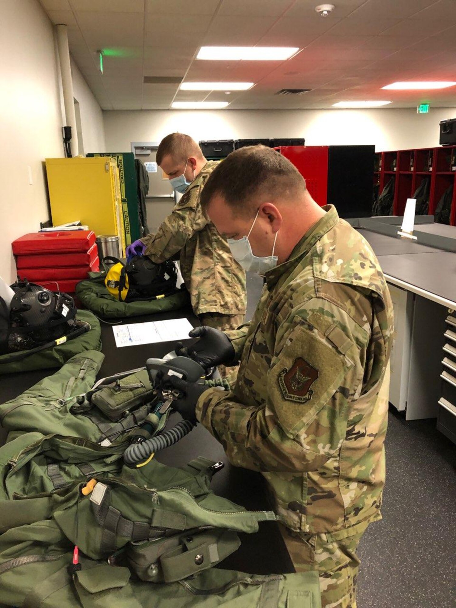 Tech. Sgt. William Vass and Tech. Sgt. Corey Johnson from the Aircrew Flight Equipment shop in the 419th Operations Support Squadron conduct quality control inspections on pilot flight gear.