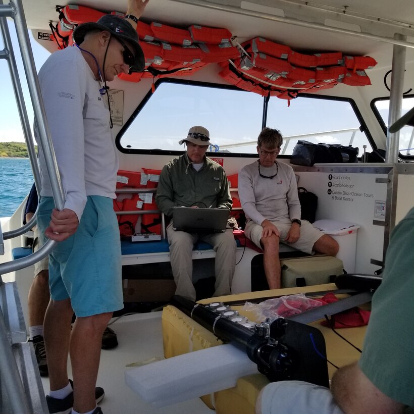 The U.S. Army Engineer and Development Center’s Justin Wilkens, a research biologist with the Environmental Laboratory, checks the waypoints using the SubSeaSail’s G6 navigation software on his laptop. The unmanned surface vessel was taken to Vieques, an island off the coast of Puerto Rico, for a demonstration by Wilkens and a team of ERDC-EL research biologists, including Dr. Guilherme Lotufo and Dr. Mark Ballentine. The USV gathered data indicating the presence of munitions constituents from unexploded underwater ordnance, a problem at sites around the world. Chris Todter, far left, a SubSeaSail partner, and Tom Goddard, far right, SubSeaSail Fabrication and Testing, are also visible in the photo.