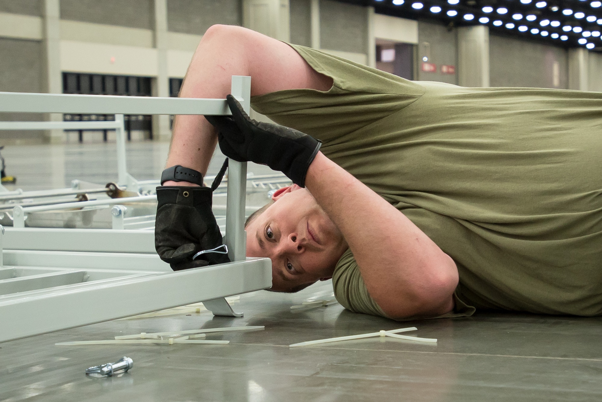 Tech. Sgt. Brandon Hall of the Kentucky Air National Guard’s 123rd Civil Engineer Squadron sets up hospital beds at the Kentucky Fair and Exposition Center in Louisville, Ky., April 11, 2020. The site, which is expected to be operational April 15, will serve as an Alternate Care Facility for patients suffering from COVID-19 if area hospitals exceed available capacity. The location initially can treat up to 288 patients and is scalable to 2,000 beds. (U.S. Air National Guard photo by Dale Greer)