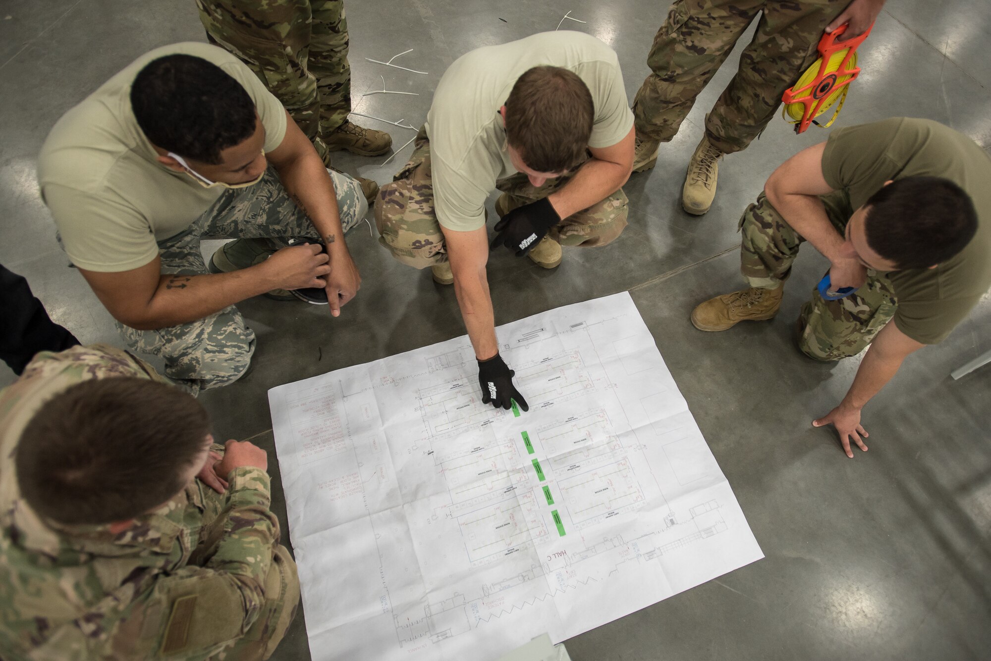 Members of the Kentucky Air National Guard’s 123rd Civil Engineer Squadron consult plans before setting up hospital beds and clinical space at the Kentucky Fair and Exposition Center in Louisville, Ky., April 11, 2020. The site, which is expected to be operational April 15, will serve as an Alternate Care Facility for patients suffering from COVID-19 if area hospitals exceed available capacity. The location initially can treat up to 288 patients and is scalable to 2,000 beds. (U.S. Air National Guard photo by Dale Greer)