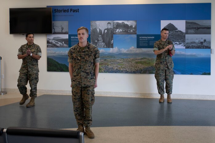 U.S. Marine Corps Col. Raul Lianez, commanding officer, Marine Corps Base Hawaii, and Sgt. Maj. Charles Wells, sergeant major, MCBH applaud Sgt. Travis J. Kuhn's after presenting him the Navy and Marine Corps Achievement Medal for impactful achievement while serving as an Air Traffic Controller, Marine Corps Air Station Kaneohe Bay, Marine Corps Base Hawaii, Apr. 14, 2020. Over the past sixty days, Kuhn consistently performed his demanding duties in an exemplary and highly professional manner in accomplishing the mission of providing air traffic control, ensuring mission readiness during the COVID-19 outbreak. (U.S. Marine Corps photo by Sgt. Alex Kouns) (U.S. Marine Corps photo by Sgt. Alex Kouns)