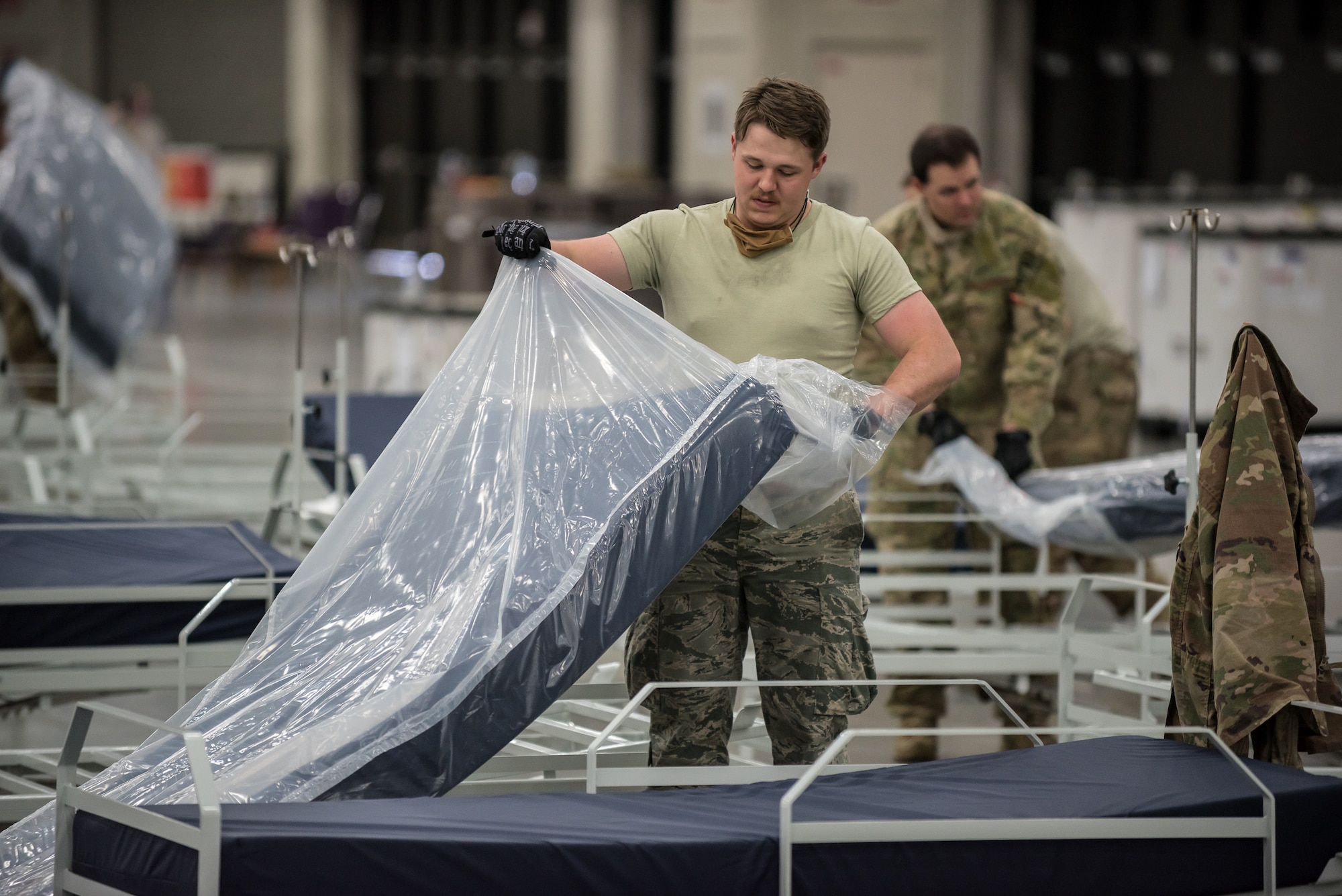 Airman 1st Class Steve Shaffer of the Kentucky Air National Guard's 123rd Airlift Wing places a mattress on a hospital bed at the Kentucky Fair and Exposition Center in Louisville, Ky., April 11, 2020. The site, which is expected to be operational April 15, will serve as an Alternate Care Facility for patients suffering from COVID-19 if area hospitals exceed available capacity. The location initially can treat up to 288 patients and is scalable to 2,000 beds. (U.S. Air National Guard photo by Dale Greer)