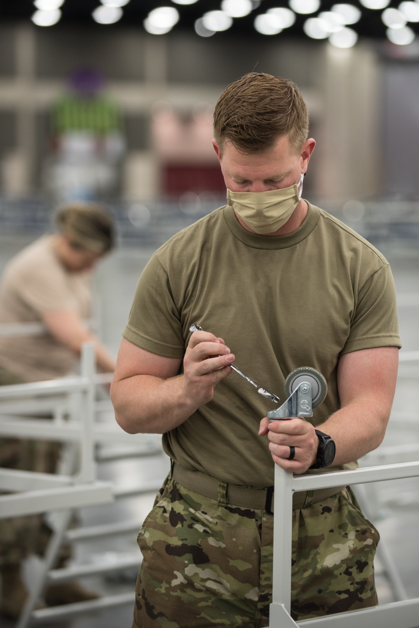 Capt. Jason Selby of the Kentucky Air National Guard’s 123rd Civil Engineer Squadron sets up hospital beds and clinical space at the Kentucky Fair and Exposition Center in Louisville, Ky., April 13, 2020. The site, which is expected to be operational April 15, will serve as an Alternate Care Facility for patients suffering from COVID-19 if area hospitals exceed available capacity. The location initially can treat up to 288 patients and is scalable to 2,000 beds. (U.S. Air National Guard photo by Dale Greer)