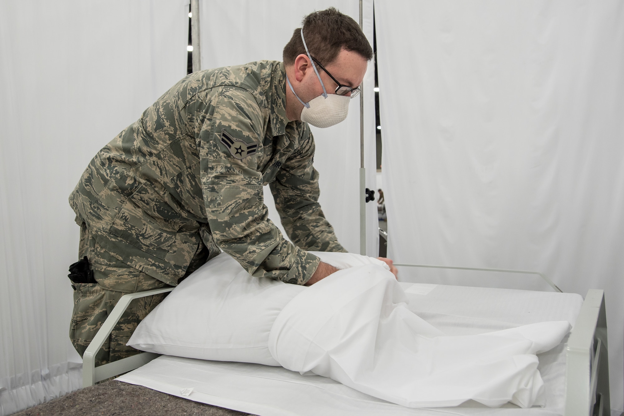 Airman 1st Class Trevor Johnson of the Kentucky Air National Guard’s 123rd Civil Engineer Squadron cases pillows for an Alternate Care Facility at the Kentucky Fair and Exposition Center in Louisville, Ky., April 14, 2020. The site, which is expected to be operational April 15, will treat patients suffering from COVID-19 if area hospitals exceed available capacity. The location initially will offer care for up to 288 patients and is scalable to 2,000 beds. (U.S. Air National Guard photo by Dale Greer)