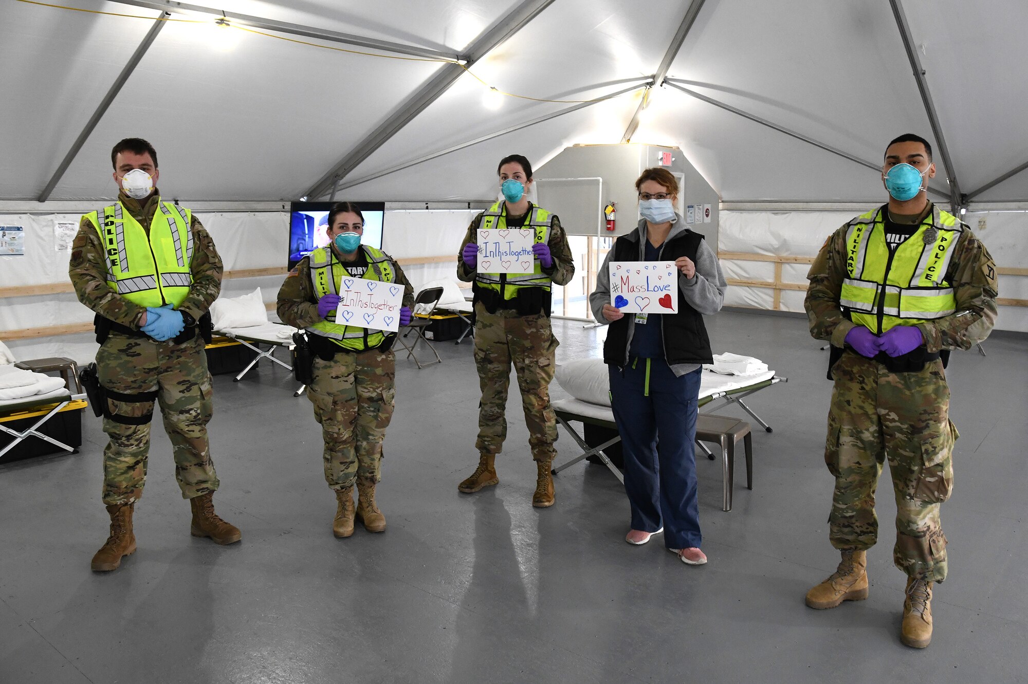 Airmen and Soldiers of the Massachusetts National Guard take a photo they respond together to help their communities during the COVID-19 response. Security Forces Airmen from the 104th Fighter Wing, Barnes Air National Guard Base, Mass., and Soldiers with the 747th Military Police Company, Massachusetts Army National Guard, are providing 24-hour security for testing sites and shelters for the homeless who may be positive COVID-19. The Airmen and Soldiers are working with interagency partners Springfield Police Department to ensure security and safety for the supplies, patients, and staff. Massachusetts National Guard units were activated at the request of Governor Charlie Baker and are helping at the testing facilities as a joint-task force. (Left to Right: Spc. Haley MacDonald and Spc. Alan Navarro) (U.S. Air National Guard Photo by Senior Master Sgt. Julie Avey)