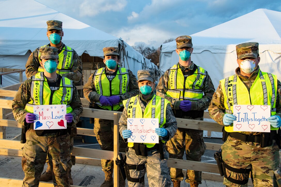 Airmen and Soldiers of the Massachusetts National Guard take a photo they respond together to help their communities during the COVID-19 response. Security Forces Airmen from the 104th Fighter Wing, Barnes Air National Guard Base, Mass., and Soldiers with the 747th Military Police Company, Massachusetts Army National Guard, are providing 24-hour security for testing sites and shelters for the homeless who may be positive COVID-19. The Airmen and Soldiers are working with interagency partners Springfield Police Department to ensure security and safety for the supplies, patients, and staff. Massachusetts National Guard units were activated at the request of Governor Charlie Baker and are helping at the testing facilities as a joint-task force. (Left to Right: Spc. Haley MacDonald and Spc. Alan Navarro) (U.S. Air National Guard Photo by Senior Master Sgt. Julie Avey)