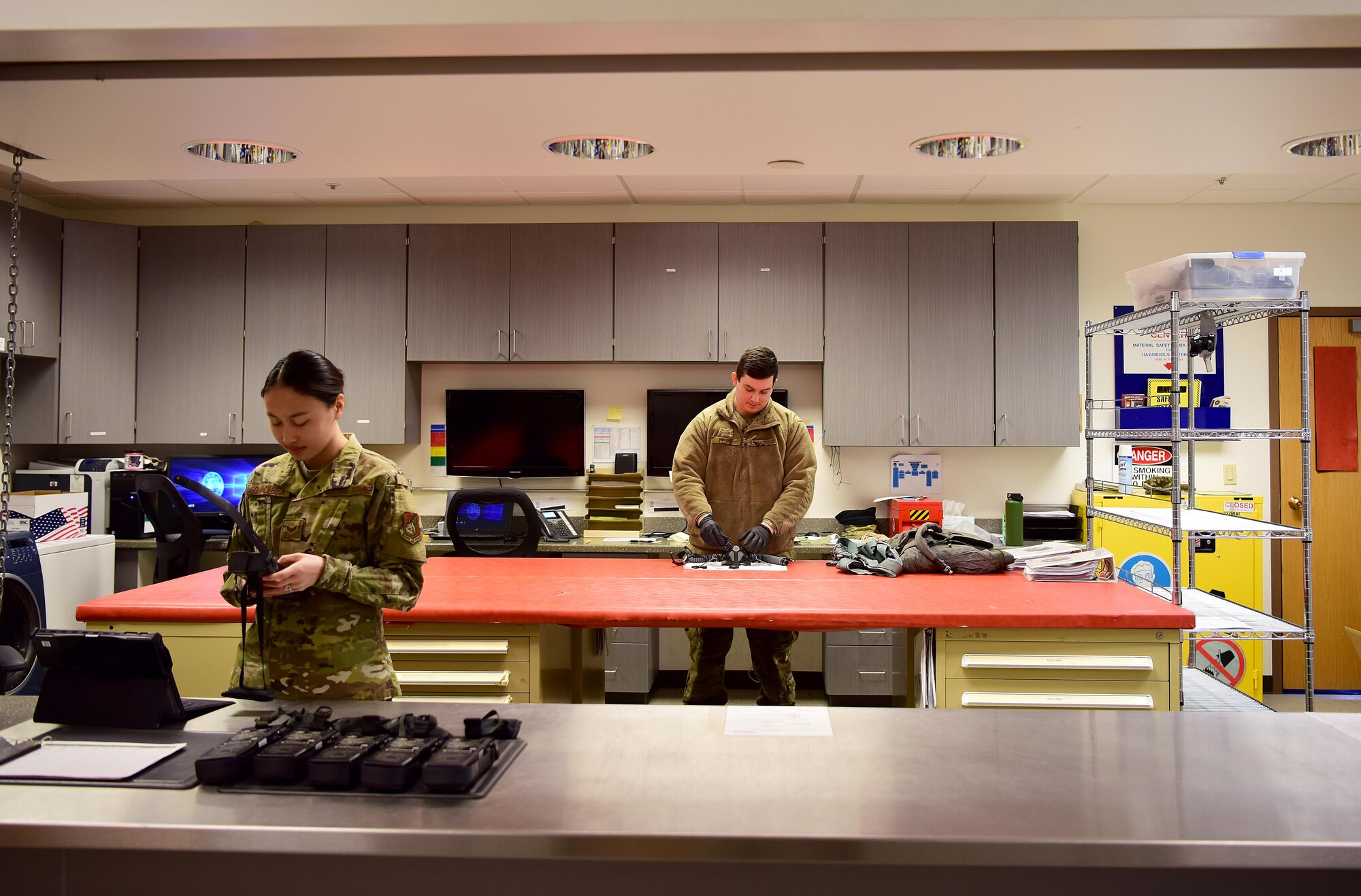 U.S. Air Force Senior Airman Lillie Schindlbeck and SrA Alex Perry, both 354th Aircrew Flight Equipment journeymen, work at the 18th Aggressor Squadron AFE shop April 6, 2020, at Eielson Air Force Base, Alaska.