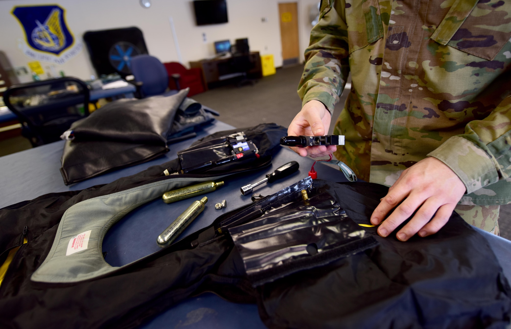 U.S. Air Force Staff Sgt. Ross Duggar, a 354th Aircrew Flight Equipment craftsman, inspects an LPU 38-P life preserver unit April 6, 2020, at Eielson Air Force Base, Alaska.