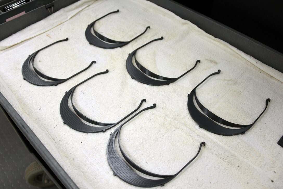 Freshly printed face shield brackets await assembly before being distributed to aid in the fight against COVID-19 at Sheppard Air Force Base, Texas, April 7, 2020. The 3D printers up to this point have been used in creating a variety of components used in the training environment. (U.S. Air Force photo by Staff Sgt. Robert L. McIlrath)